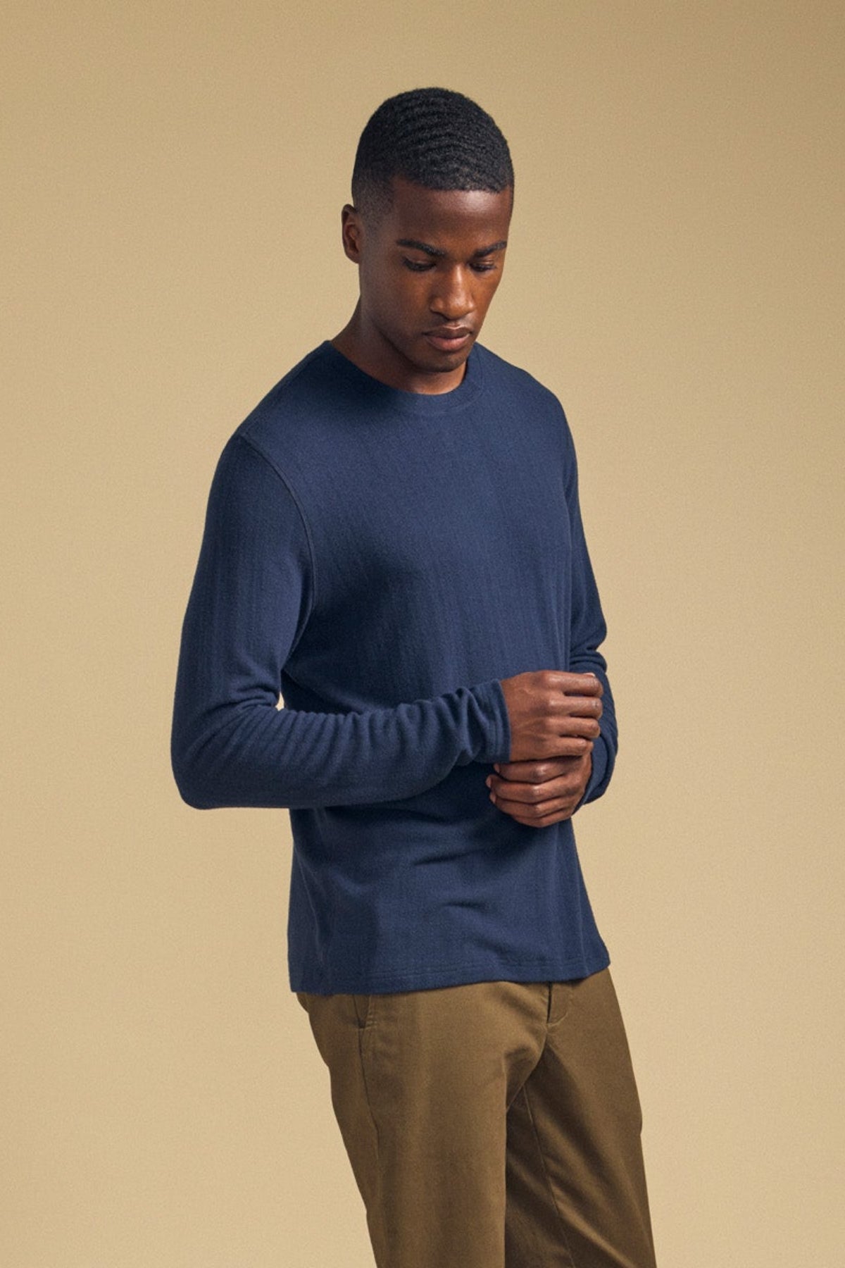 A man wearing a navy blue REDDEN CREW PULLOVER, a cozy jersey layering essential.-46288509960385