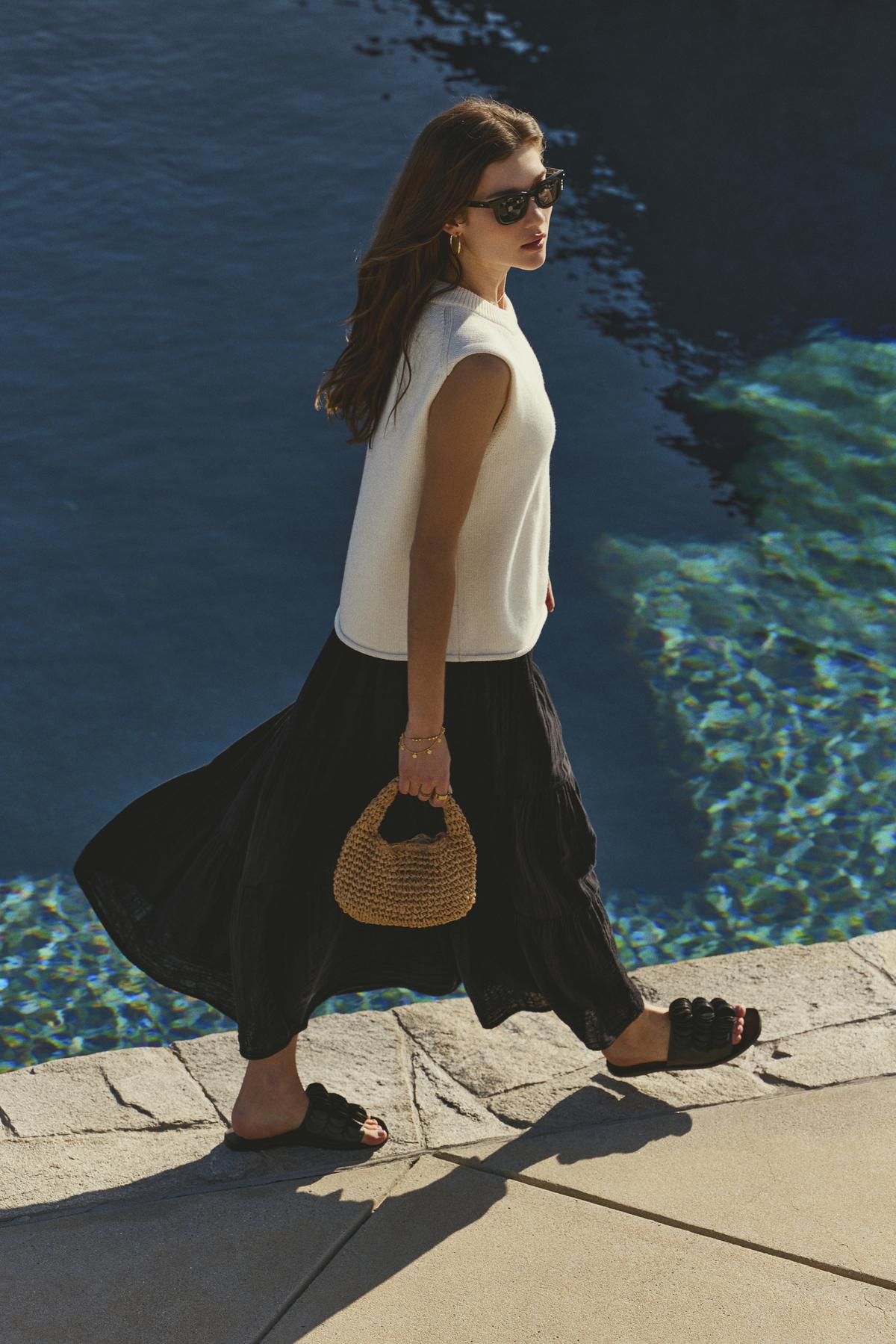   Woman walking by the water's edge, dressed in a Velvet by Graham & Spencer Danielle Cotton Gauze Tiered Skirt. 
