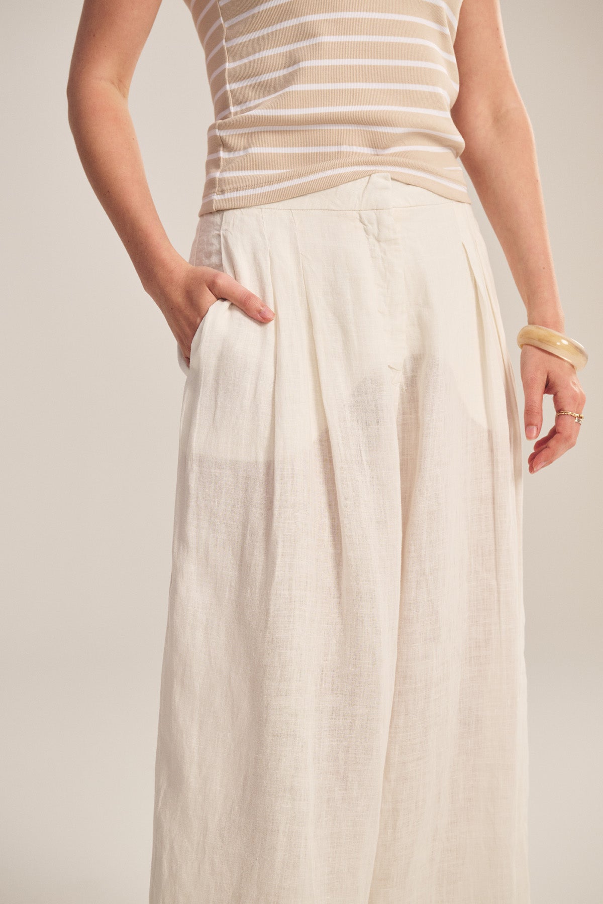 A person models the DANIKA LINEN PANT by Velvet by Graham & Spencer, styled with one hand in their pocket, set against a plain background.