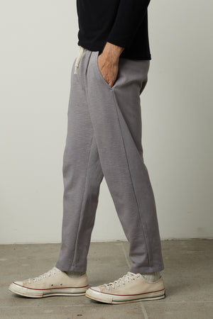 A man wearing Velvet by Graham & Spencer PARKER sweatpants and sneakers.