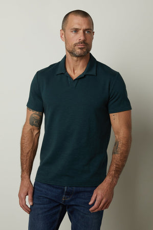 A man wearing a Velvet by Graham & Spencer DILAN COTTON BLEND POLO shirt and jeans.