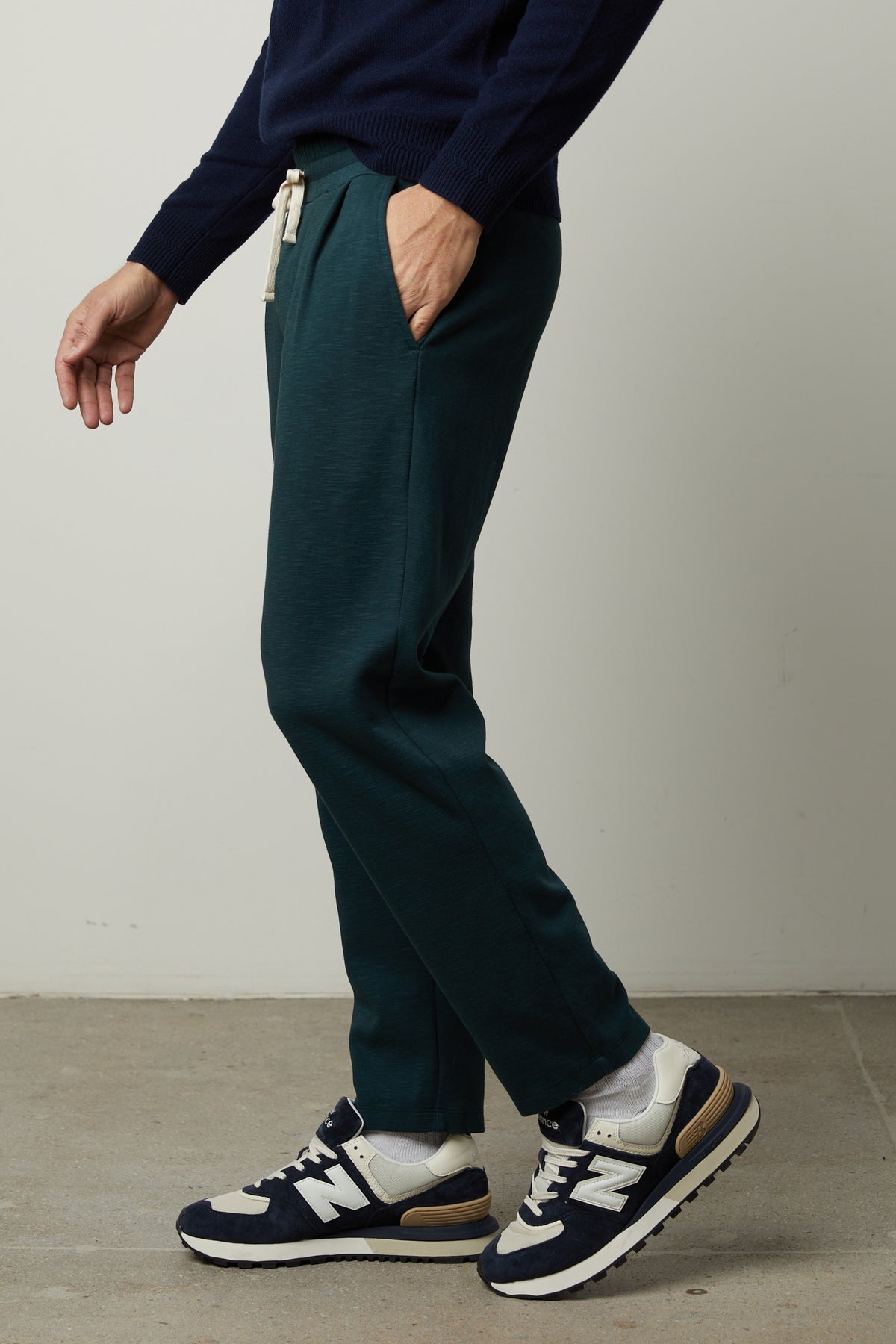 A man wearing a sweater and Velvet by Graham & Spencer PARKER SWEATPANT in dark green.-35179764940993
