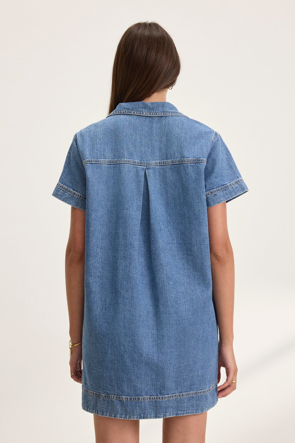 The back view shows someone wearing the Velvet by Graham & Spencer DELANA DENIM DRESS, featuring short sleeves and a central pleat detail.-38802060280001
