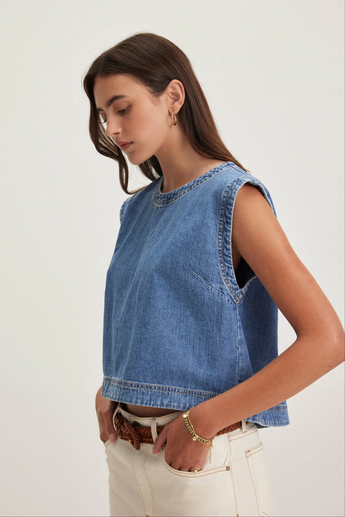 A woman models the LOREN DENIM TOP by Velvet by Graham & Spencer, paired with white pants against a plain background.-38820684267713