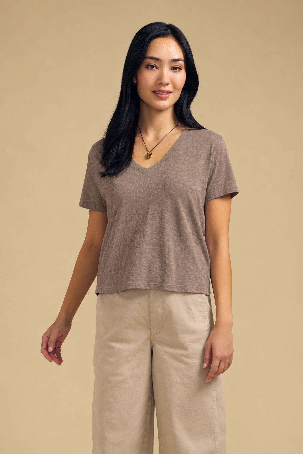 Woman wearing a brown ELISHA TEE in cotton slub paired with tan wide-leg trousers.-46490611843265