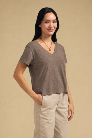A woman wears a Velvet by Graham & Spencer ELISHA TEE tucked into beige pants.
