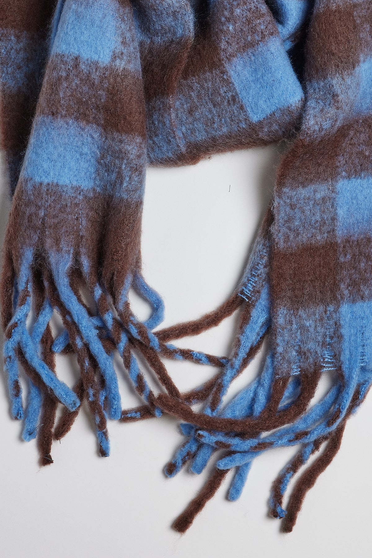 A classic Velvet by Graham & Spencer plaid scarf with fringe ends, the ELLE PLAID SCARF offers warmth and comfort in shades of blue and brown.-35211033575617