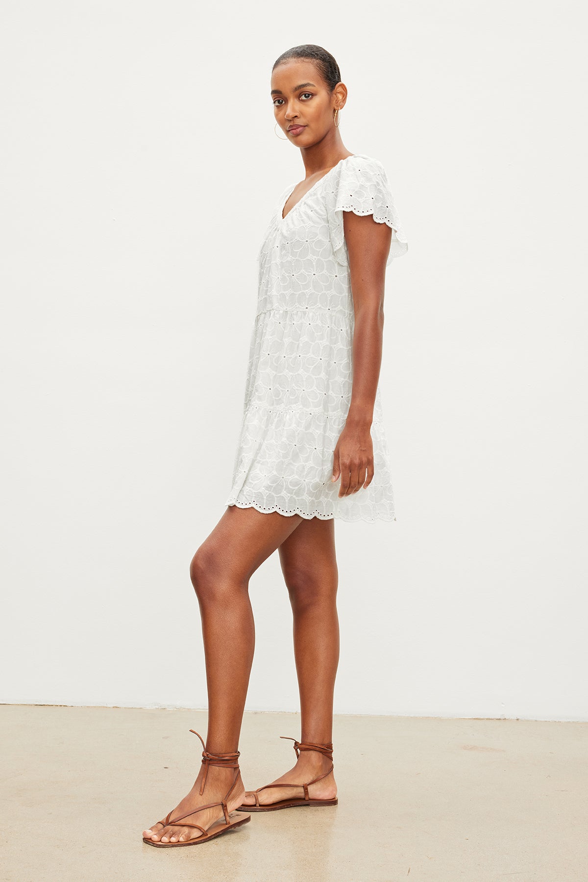   The model is wearing a WYNETTE EMBROIDERED COTTON DRESS by Velvet by Graham & Spencer and sandals. 