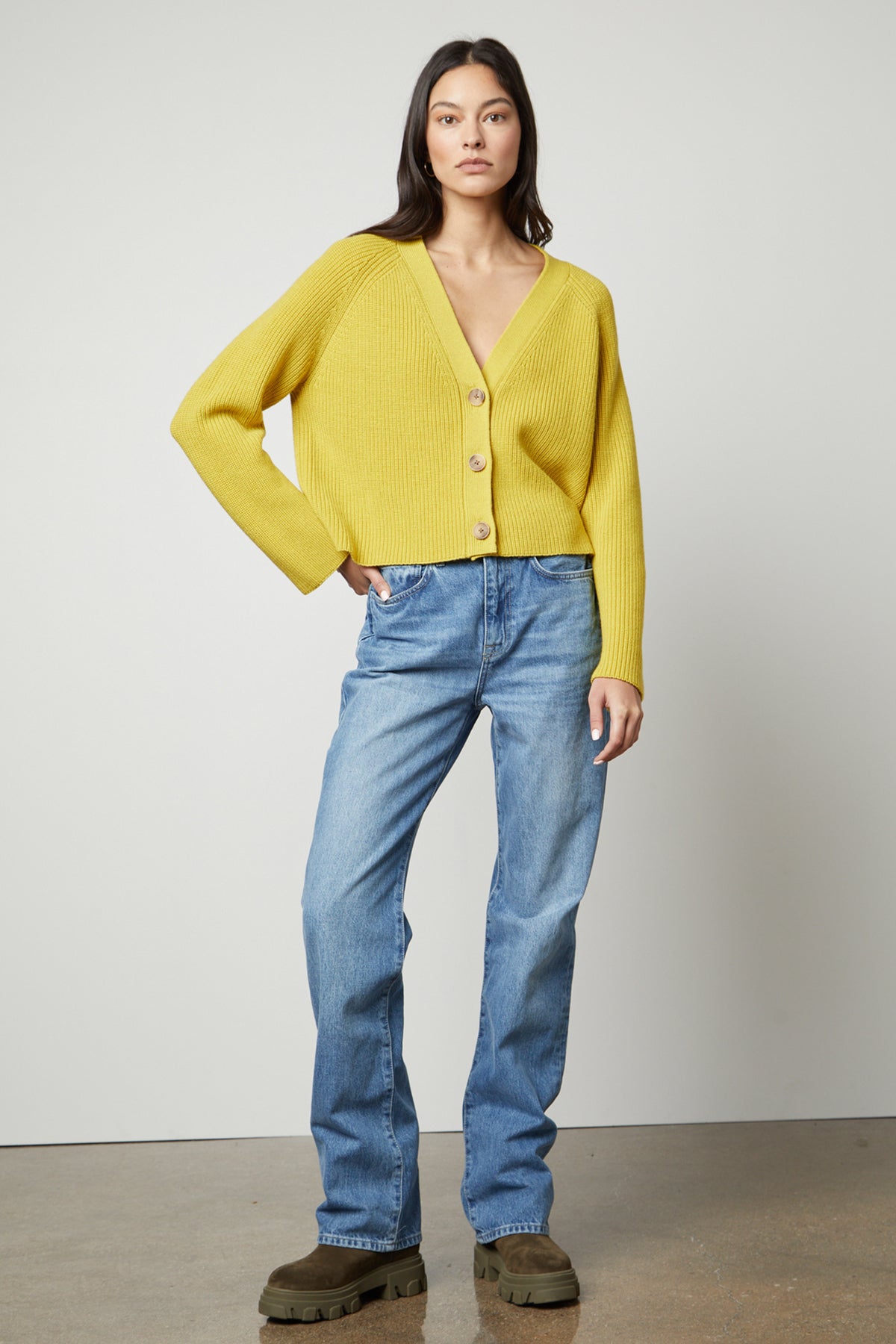   The model is wearing a Yellow MARILYN BUTTON FRONT CARDIGAN by Velvet by Graham & Spencer and jeans. 