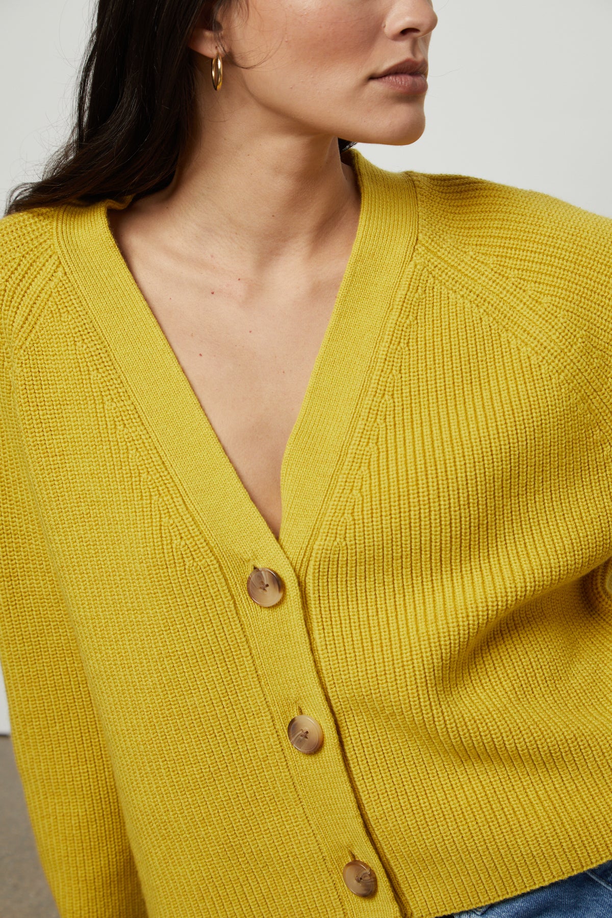 The model is wearing a yellow MARILYN BUTTON FRONT CARDIGAN sweater by Velvet by Graham & Spencer close up detail.-26727747027137