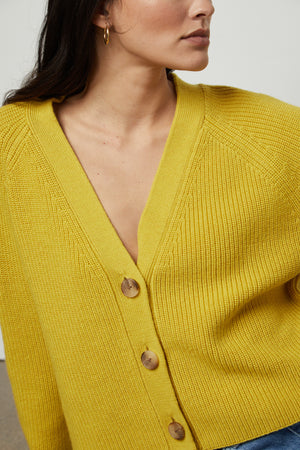 The model is wearing a yellow MARILYN BUTTON FRONT CARDIGAN sweater by Velvet by Graham & Spencer close up detail.