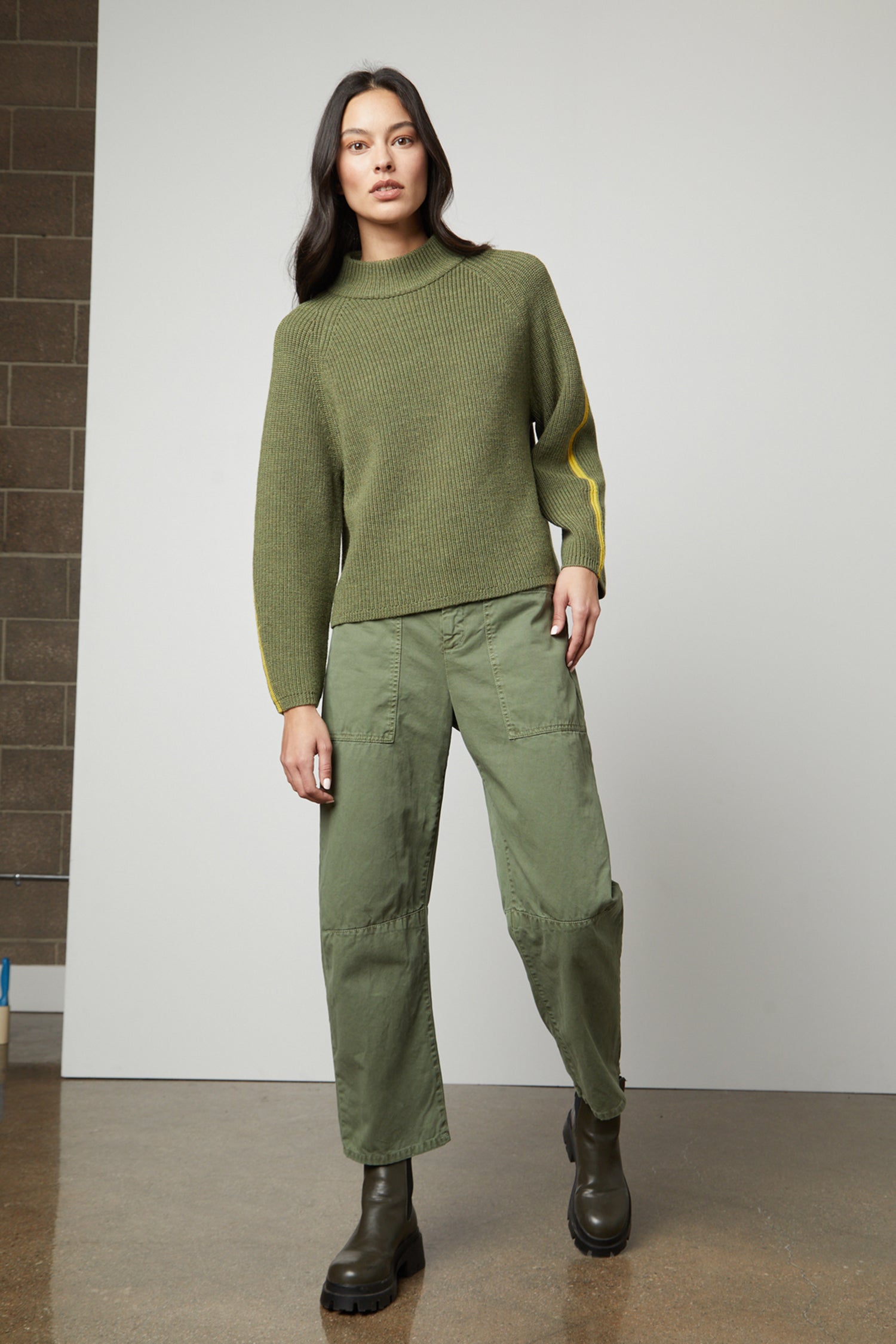   The model is wearing a comfortable TEAGAN MOCK NECK SWEATER by Velvet by Graham & Spencer. 