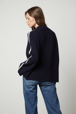 The back view of a woman wearing a Velvet by Graham & Spencer TEAGAN MOCK NECK SWEATER and jeans.