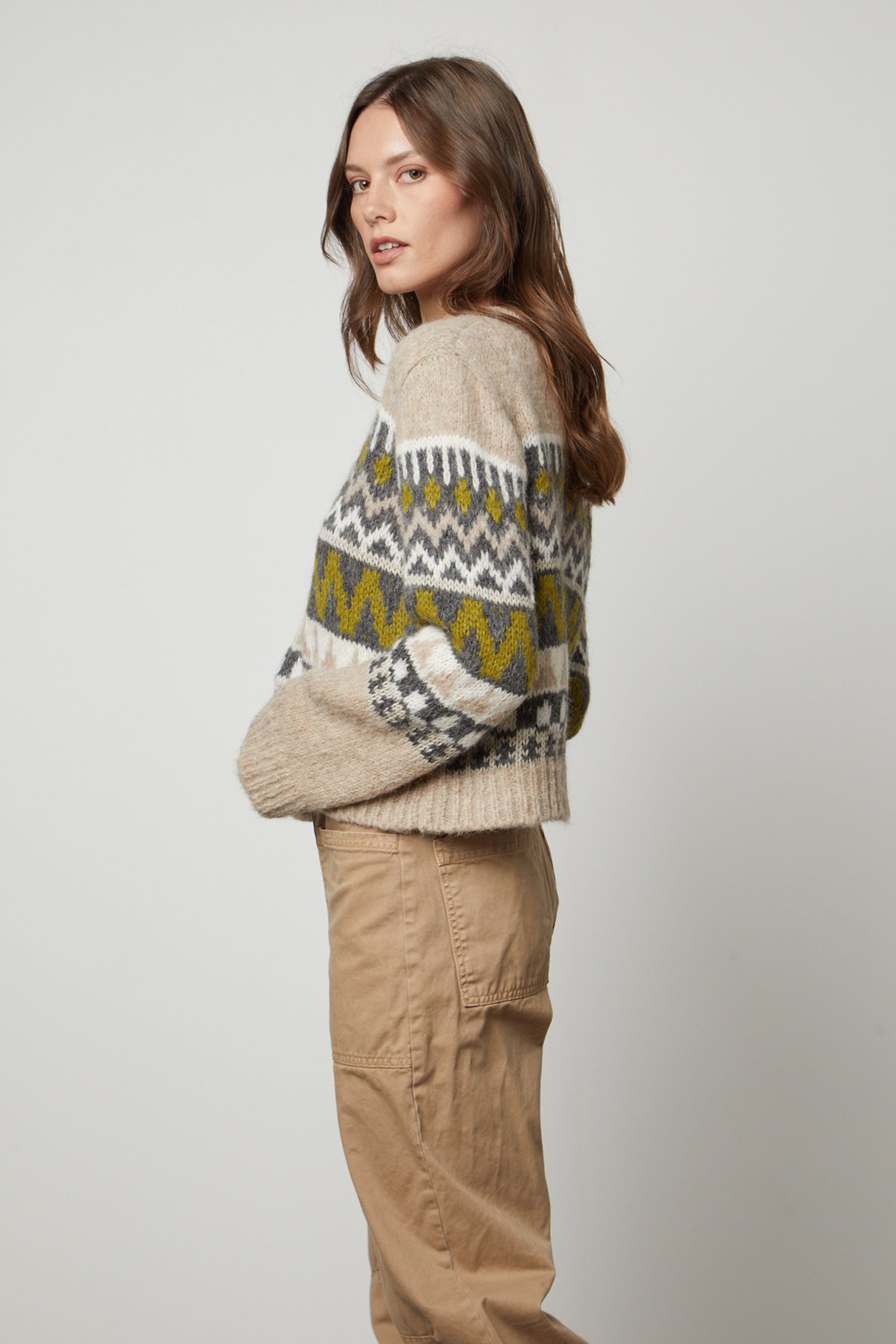   A cozy model wearing a MAKENZIE ALPACA CABLE KNIT CREW NECK SWEATER by Velvet by Graham & Spencer and khaki pants. 
