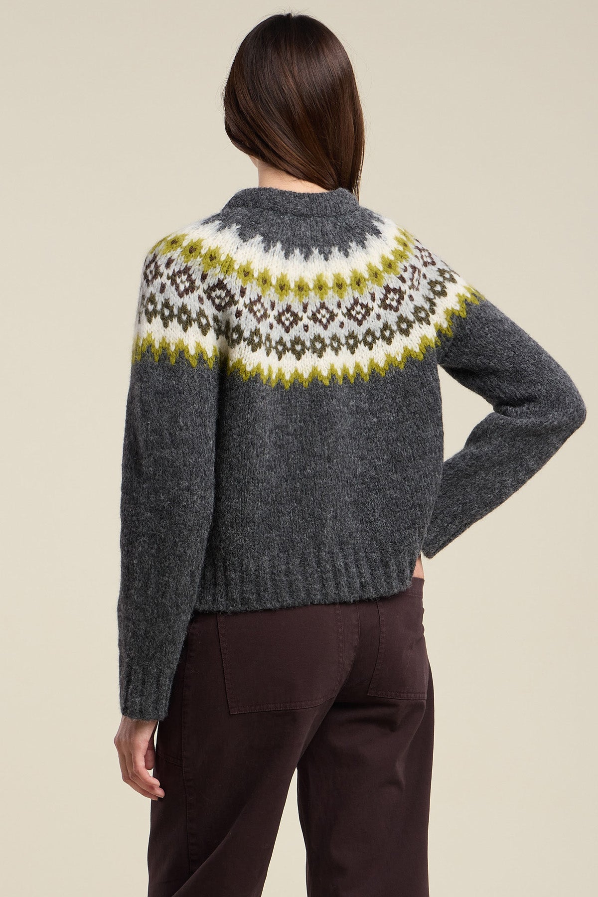 A person is shown from the back against a plain background, wearing the EDITH ALPACA SWEATER by Velvet by Graham & Spencer—a dark gray alpaca blend sweater featuring a yellow, white, and black patterned yoke—paired with dark pants.