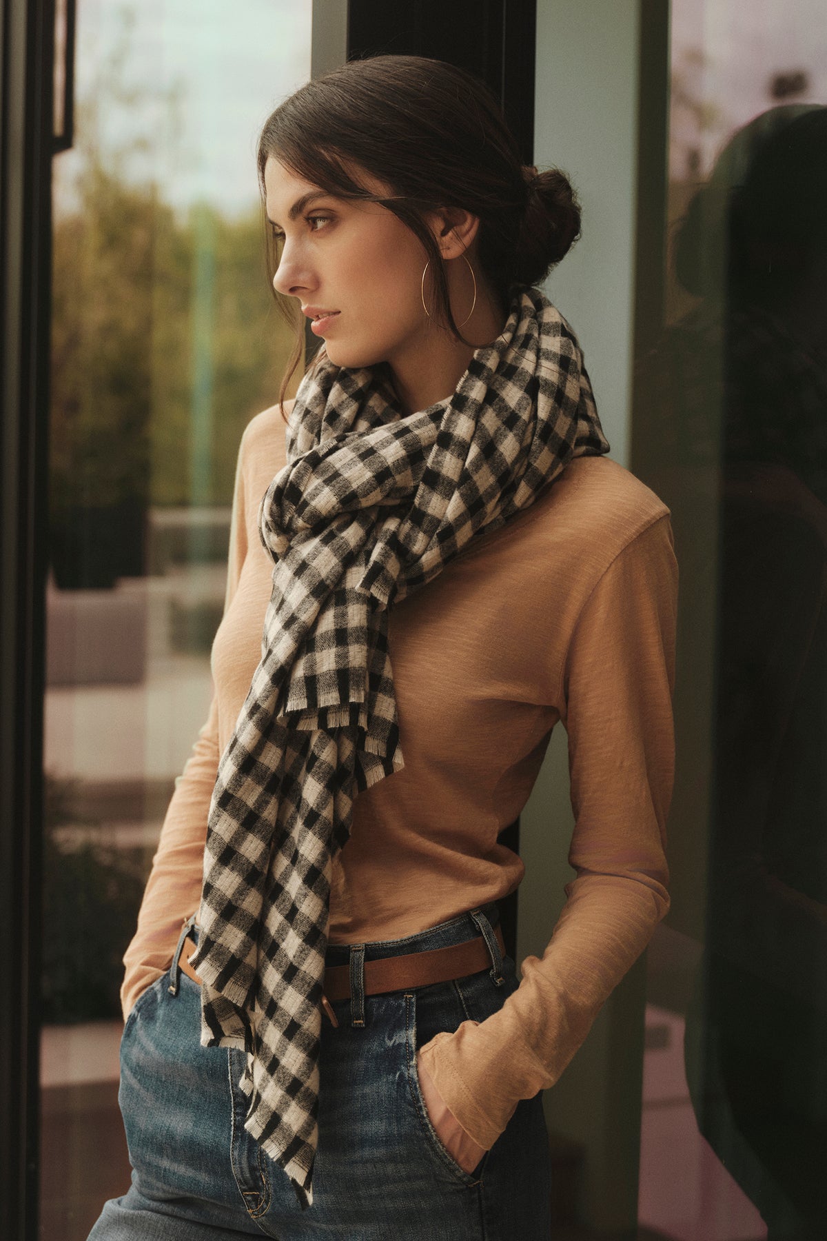 A woman wearing a black and white checkered BLAIRE ORIGINAL SLUB TEE made by Velvet by Graham & Spencer scarf made of cotton.-35782759153857