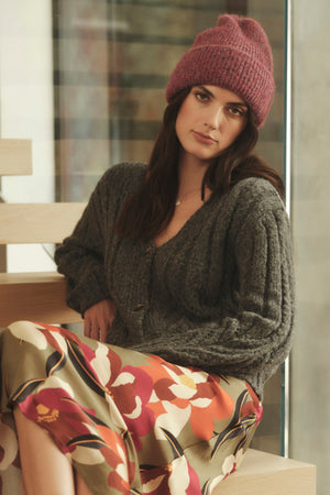 A woman wearing an ECO CUFF BEANIE by Velvet by Graham & Spencer sweater and skirt.