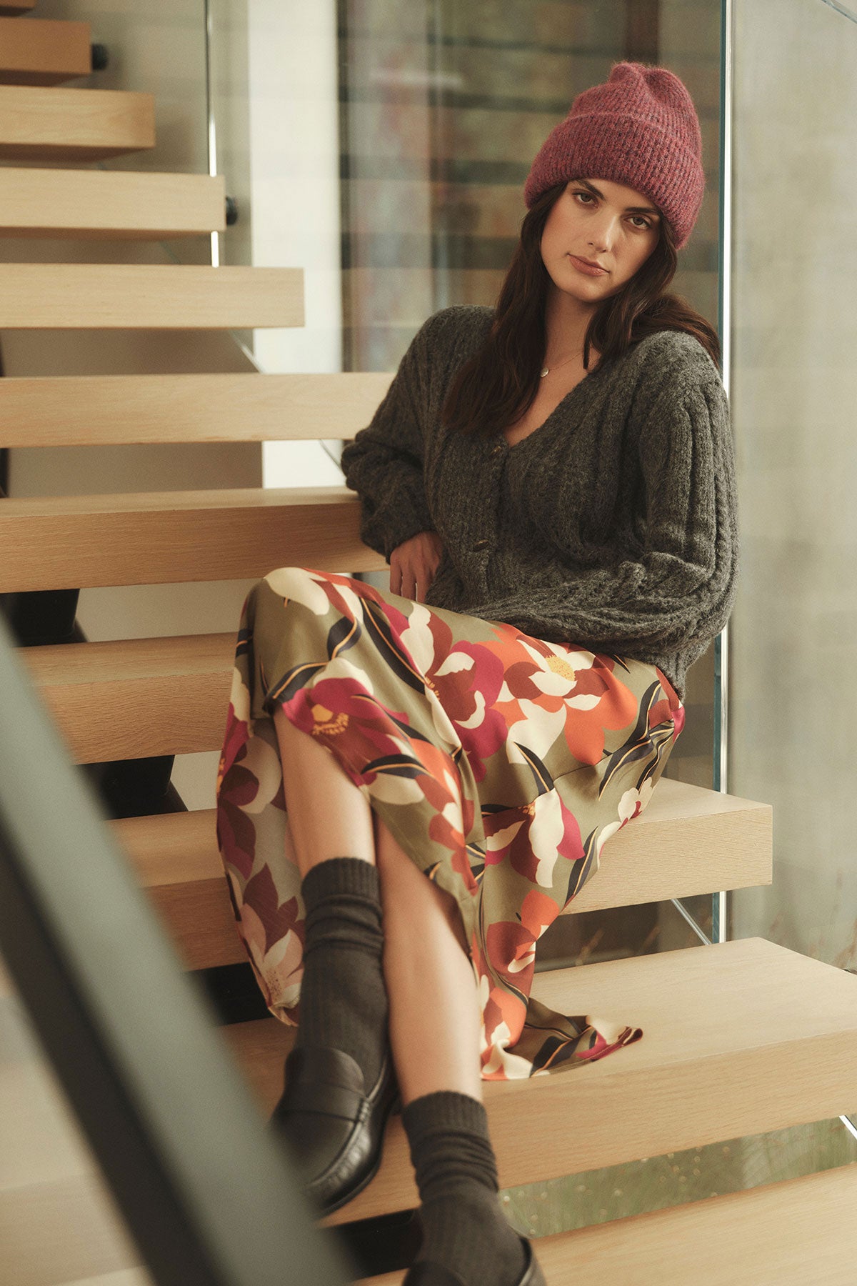 A woman is sitting on a staircase wearing a Velvet by Graham & Spencer KAIYA PRINTED SKIRT dress with an elastic waist.-35224481628353