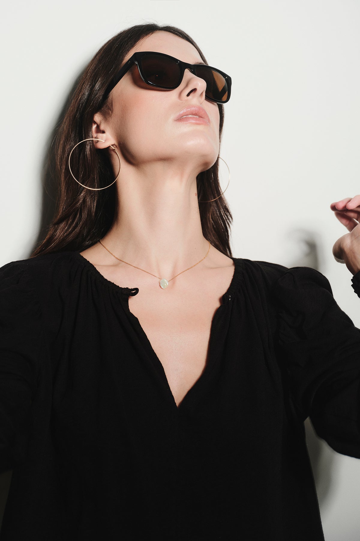 A woman wearing BYCHARI sunglasses and a black top.-26887533232321