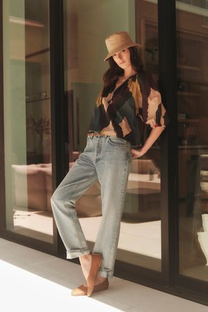 A woman wearing LIZETTE PRINTED BOHO TOP by Velvet by Graham & Spencer standing in front of a window.