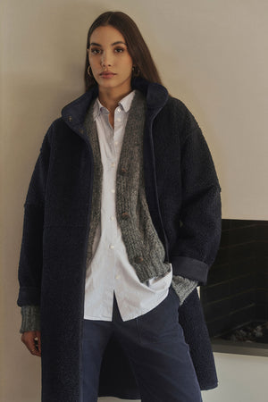 A woman wearing a navy CARA LUX SHERPA REVERSIBLE JACKET by Velvet by Graham & Spencer.