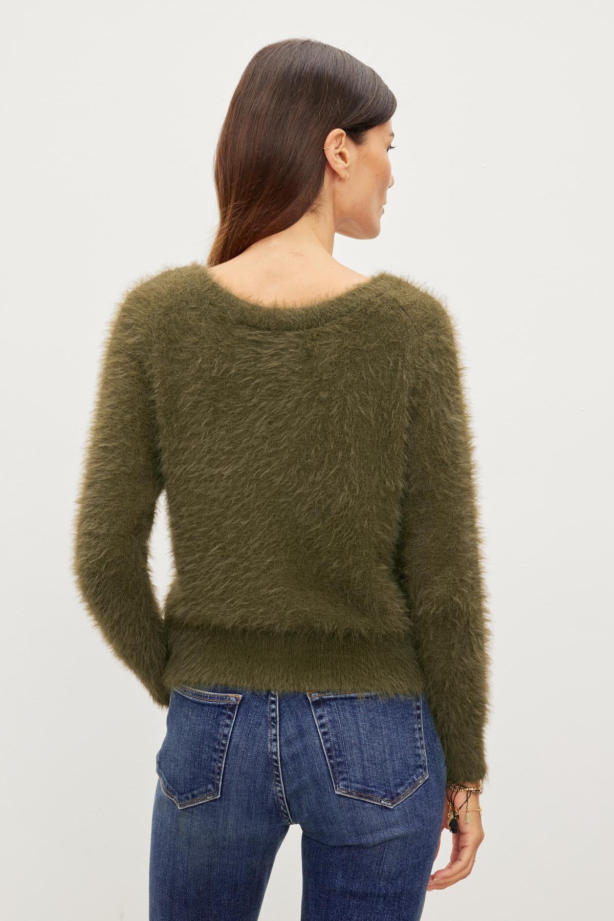   The woman's back view showcases her versatile ELLE FEATHER YARN CARDIGAN made by Velvet by Graham & Spencer. 