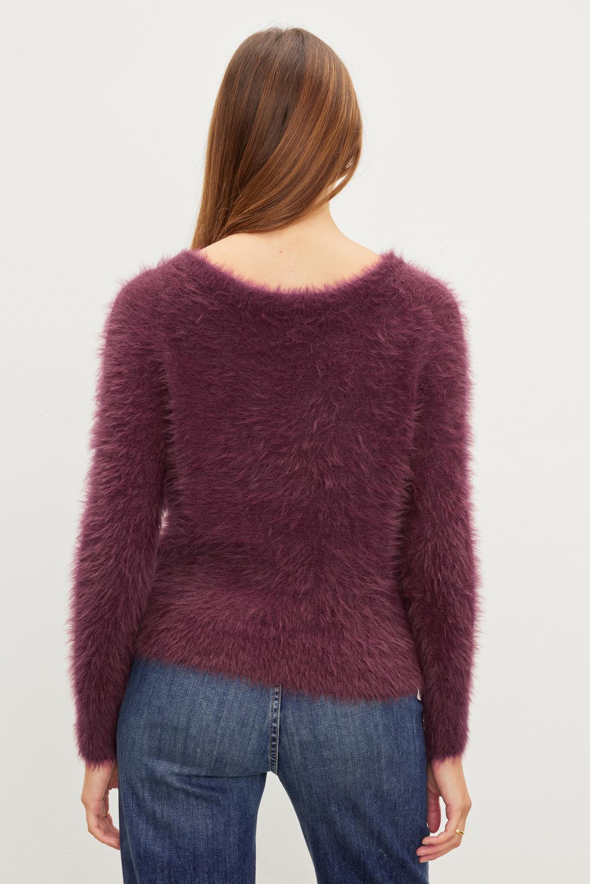 The back view of a woman wearing a Velvet by Graham & Spencer ELLE FEATHER YARN CARDIGAN sweater.-35630360035521