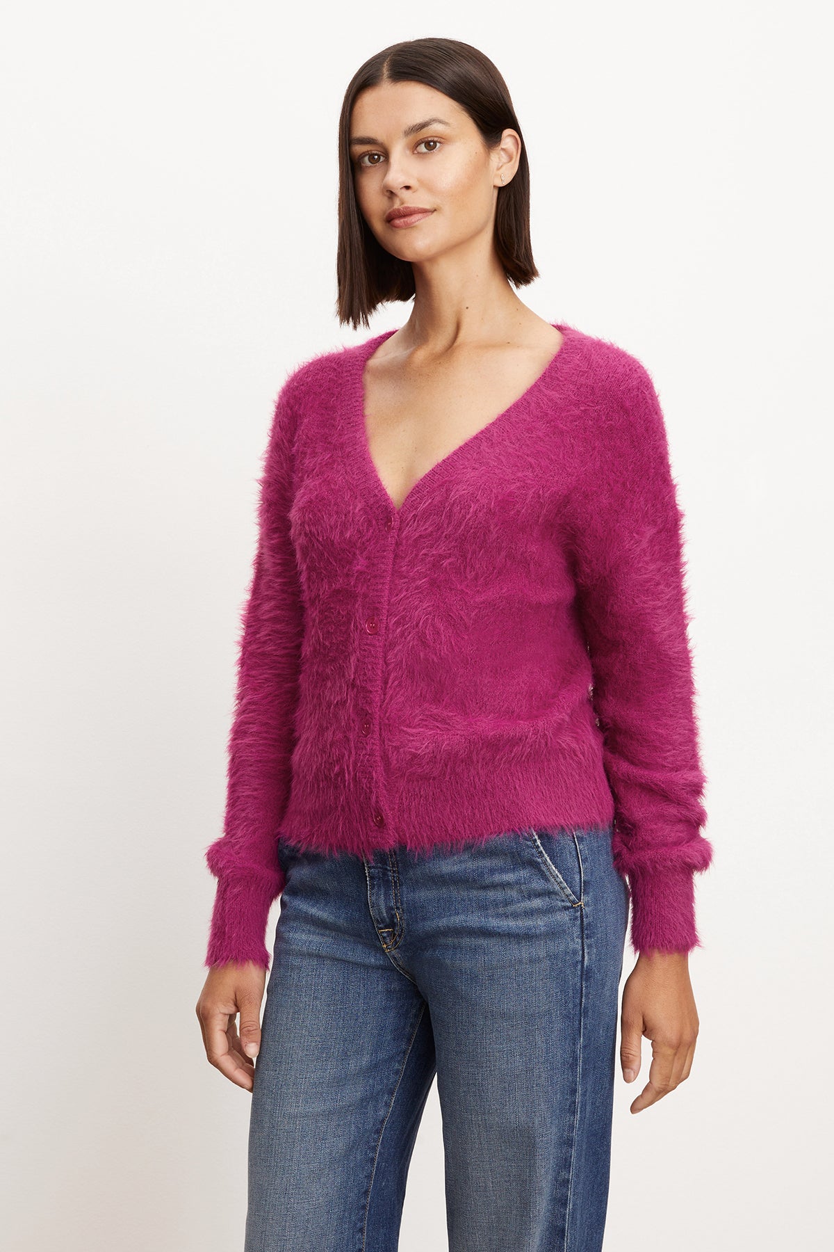   The model is wearing a pink KELSEY FEATHER YARN CARDIGAN made by Velvet by Graham & Spencer. 