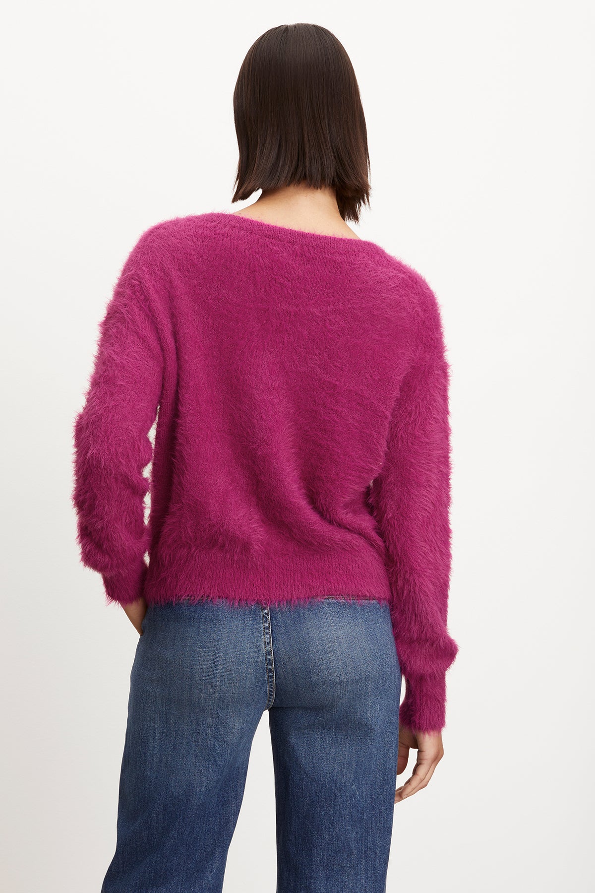   The back view of a woman wearing a Velvet by Graham & Spencer KELSEY FEATHER YARN CARDIGAN with ribbed trims. 