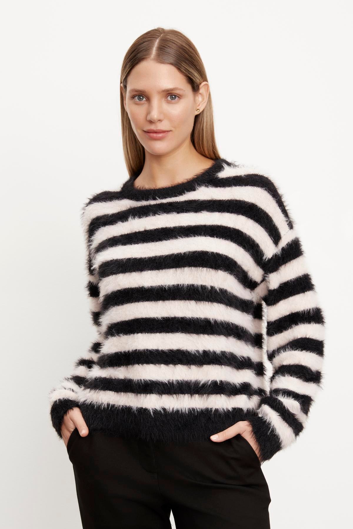   A woman wearing a Velvet by Graham & Spencer KIMBERLY FEATHER YARN CREW NECK SWEATER. 