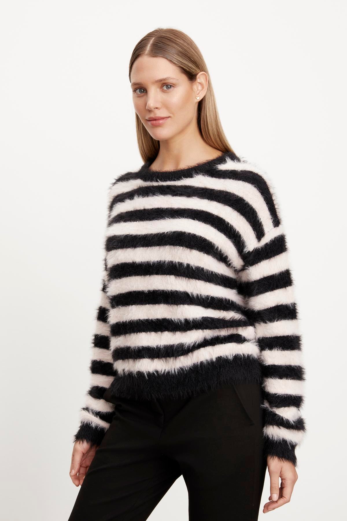 A woman wearing a Velvet by Graham & Spencer KIMBERLY FEATHER YARN CREW NECK SWEATER.-36094335254721