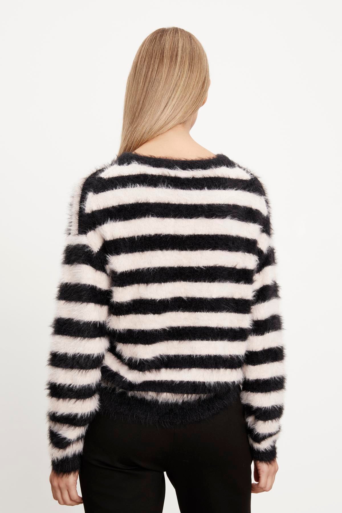   The back view of a woman wearing a Velvet by Graham & Spencer KIMBERLY FEATHER YARN CREW NECK SWEATER. 