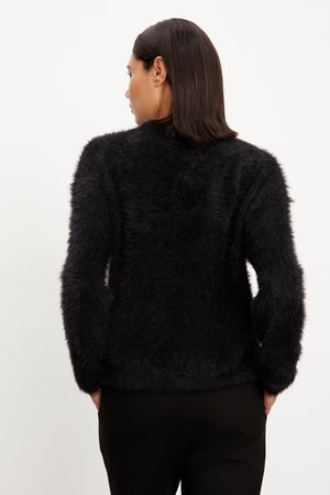 The back view of a woman wearing a Velvet by Graham & Spencer RAY FEATHER YARN CREW NECK SWEATER.