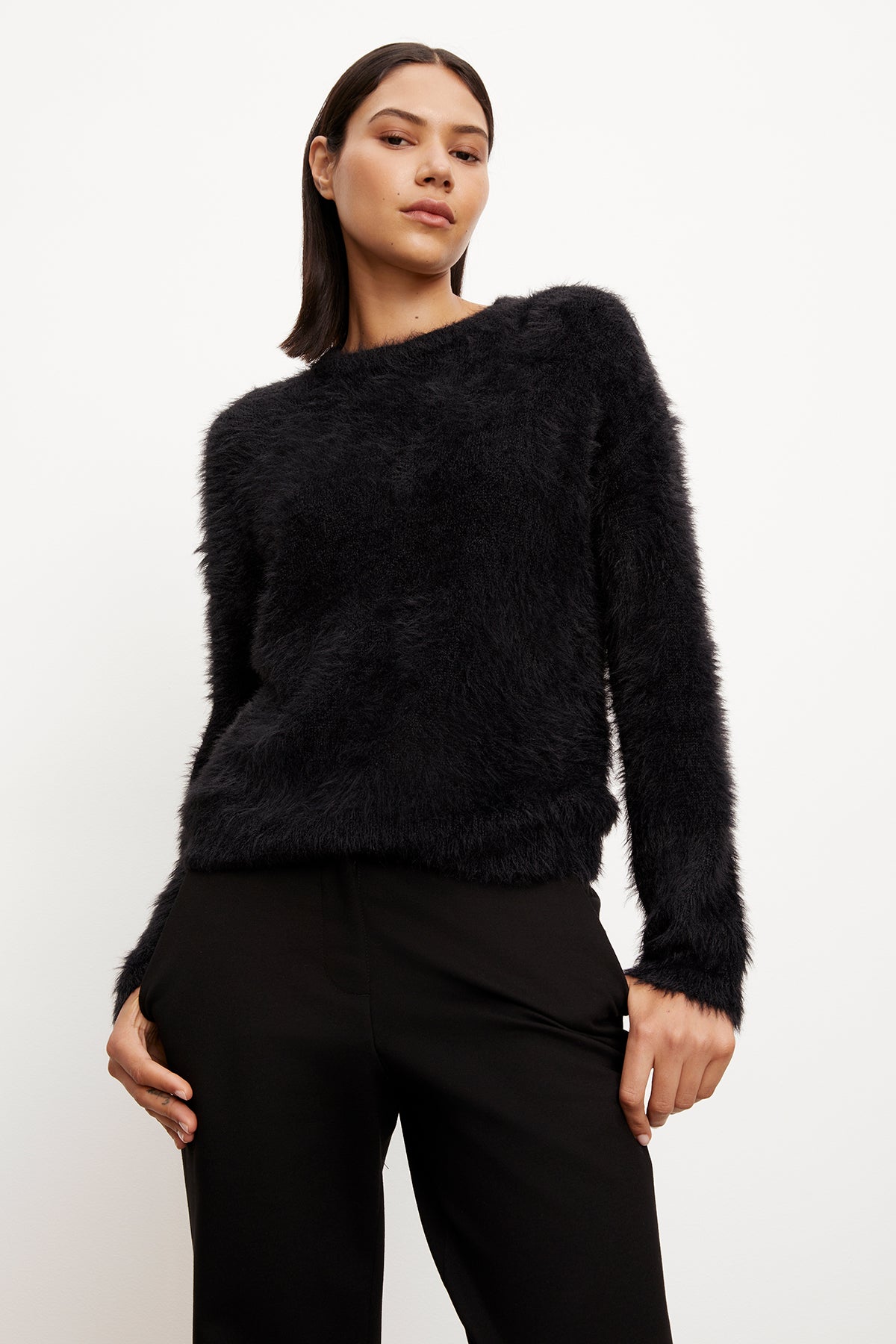The model is wearing a Velvet by Graham & Spencer RAY FEATHER YARN CREW NECK SWEATER.-35572015562945