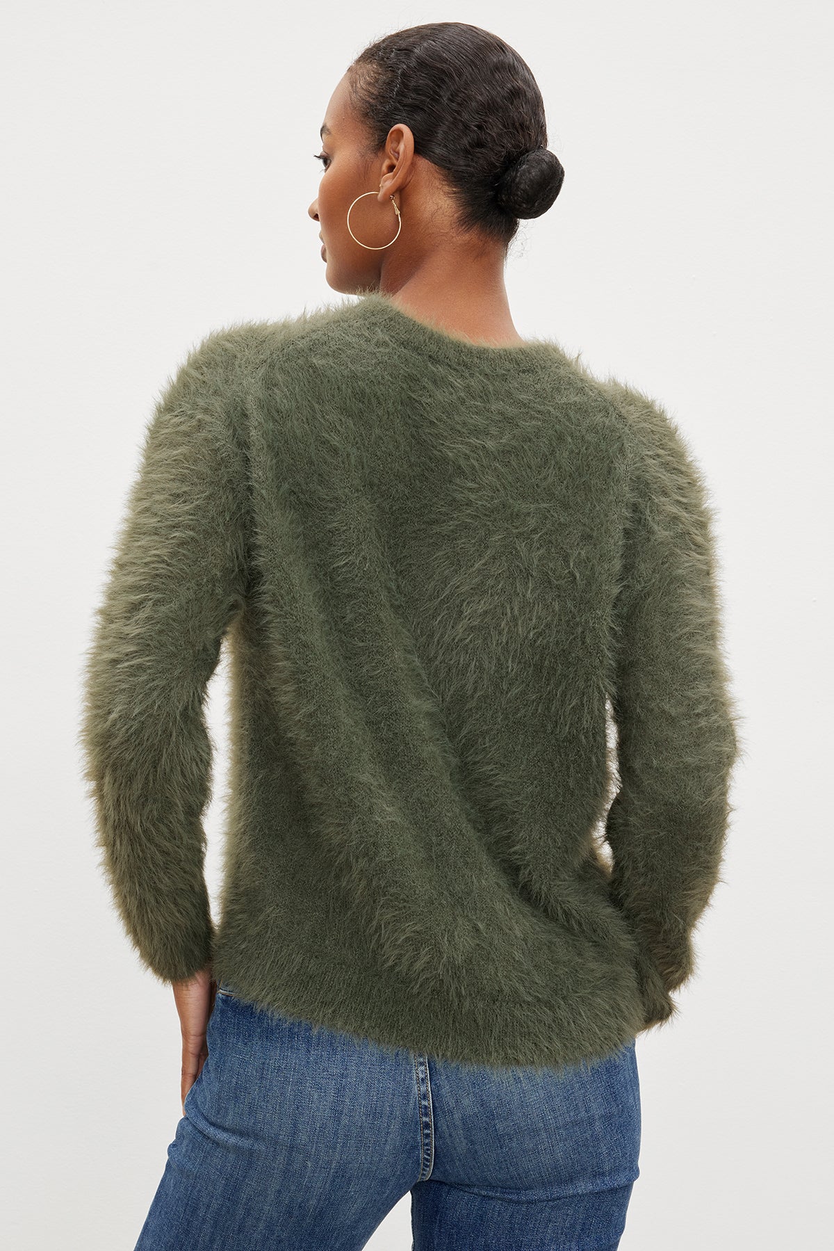  The back view of a woman wearing a Velvet by Graham & Spencer RAY FEATHER YARN CREW NECK SWEATER in a green fuzzy texture. 
