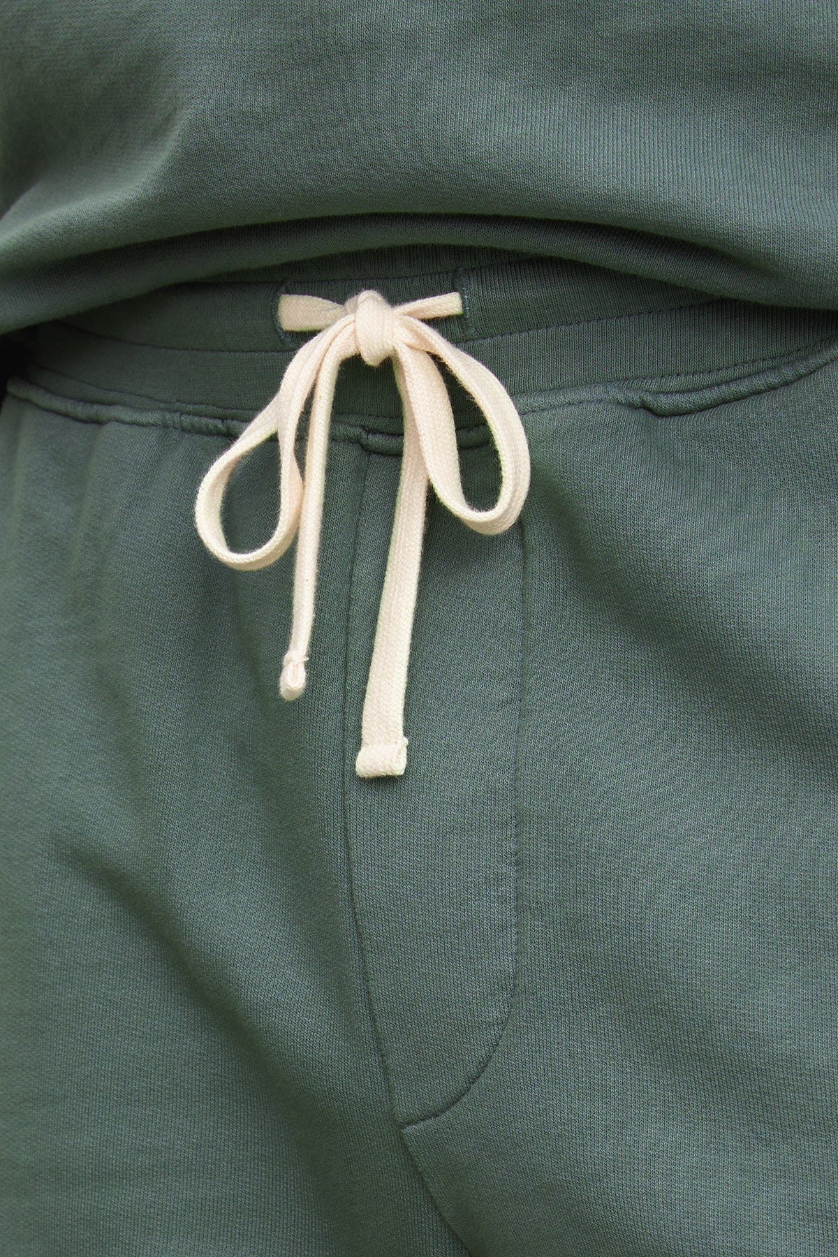   Close-up of Velvet by Graham & Spencer Beckett shorts in green with a white drawstring tied in a bow at the elastic waist. 