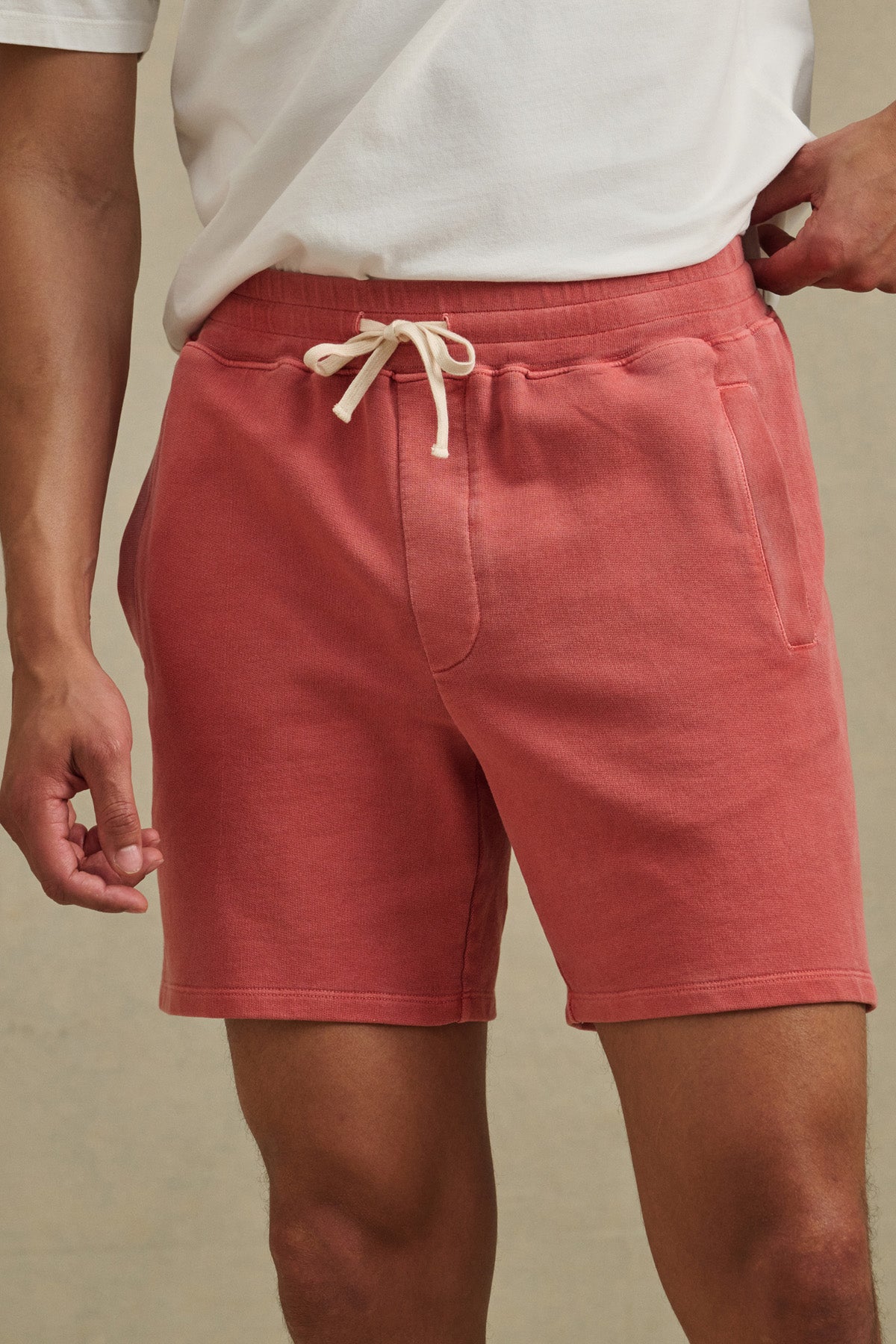 A person is shown from shoulders to mid-thigh wearing a white T-shirt and Velvet by Graham & Spencer's BOSLOW SHORT—relaxed fit French terry shorts with a drawstring waist, hands resting by their sides.