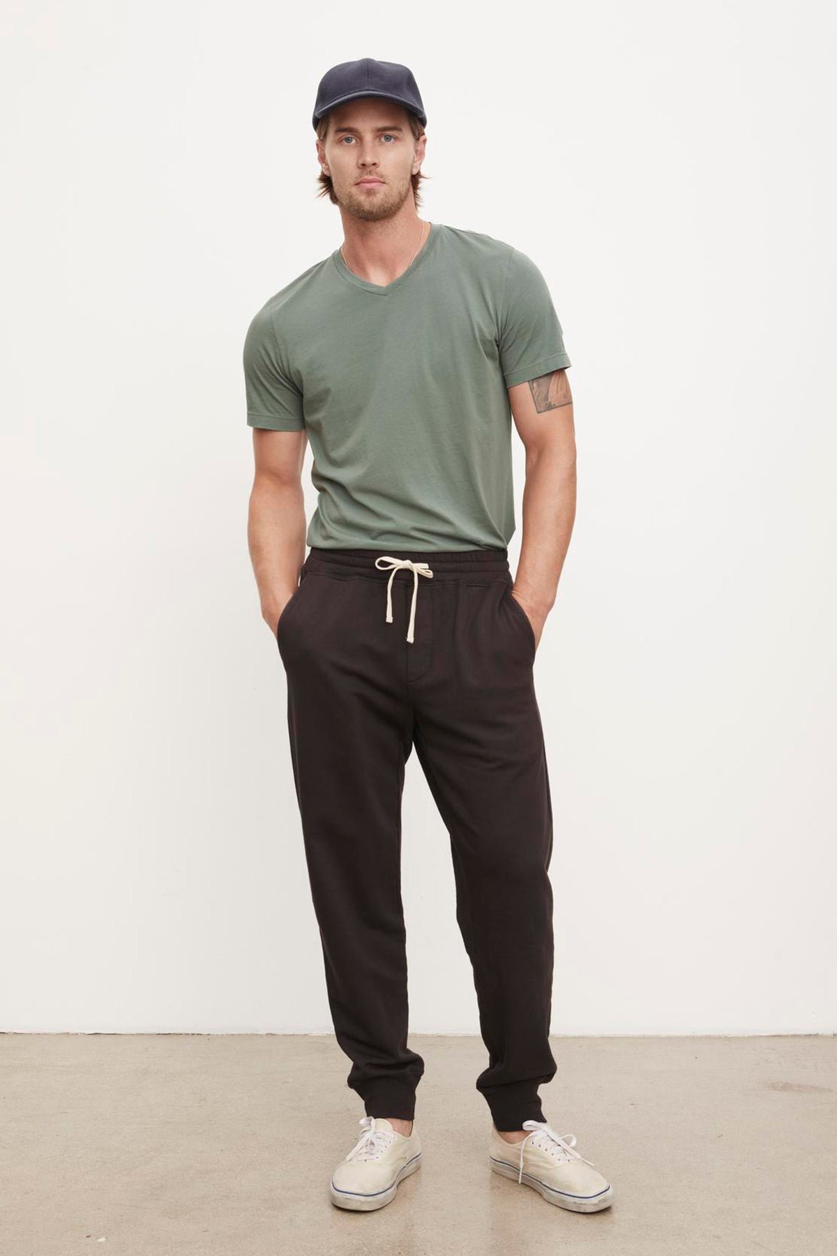   A man wearing a green t-shirt and Velvet by Graham & Spencer Dusty French Terry Sweatpants. 