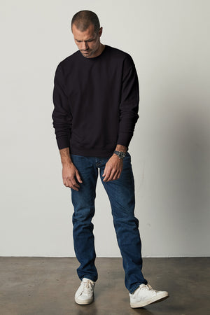 Sirus Crew Neck Sweatshirt in black with blue denim and sneakers full length front