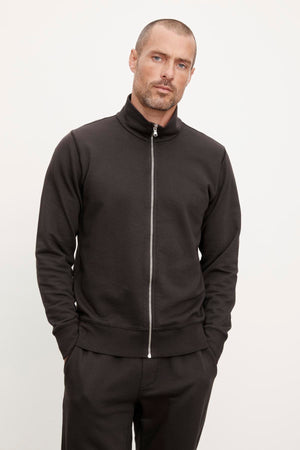 A man wearing a black Velvet by Graham & Spencer TERRY FRENCH TERRY FULL-ZIP sweatshirt from his casual wardrobe.