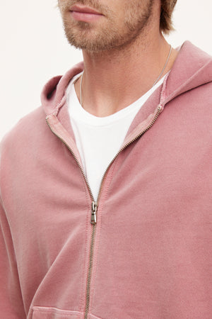Close-up of a man wearing a pink Velvet by Graham & Spencer VINCENT HOODIE over a white t-shirt, focusing on the upper chest and lower face.