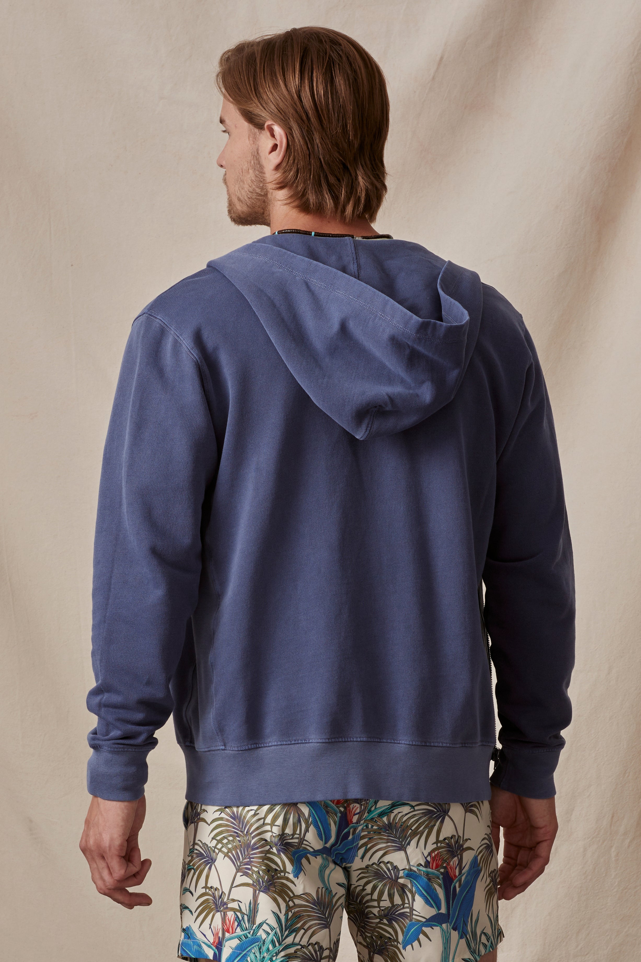   Man from behind wearing a Velvet by Graham & Spencer VINCENT HOODIE and patterned shorts, standing against a neutral backdrop. 