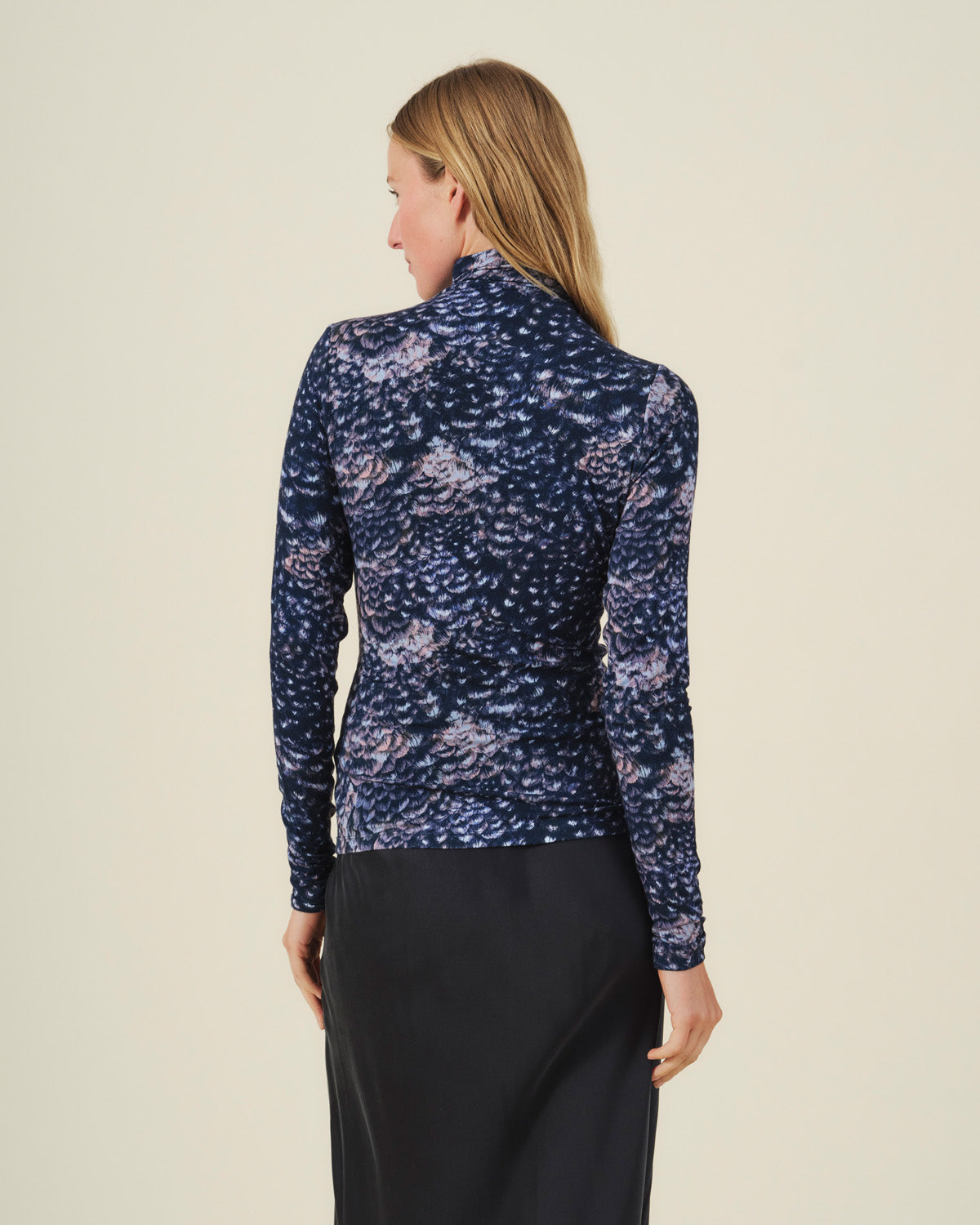 Back view of the TAYLOR PRINTED TEE by Velvet by Graham & Spencer, a long-sleeved mock neck jersey featuring a dark blue pattern of scattered, feathery shapes in shades of pink and white.