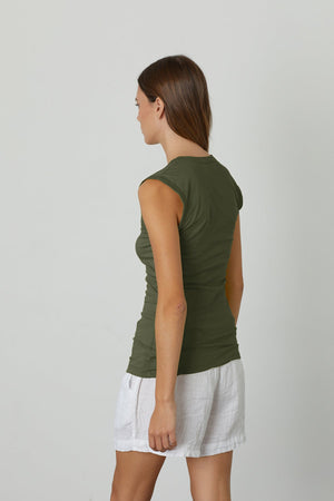 the back view of a woman wearing a Velvet by Graham & Spencer ESTINA GAUZY WHISPER FITTED TANK TOP and white shorts.