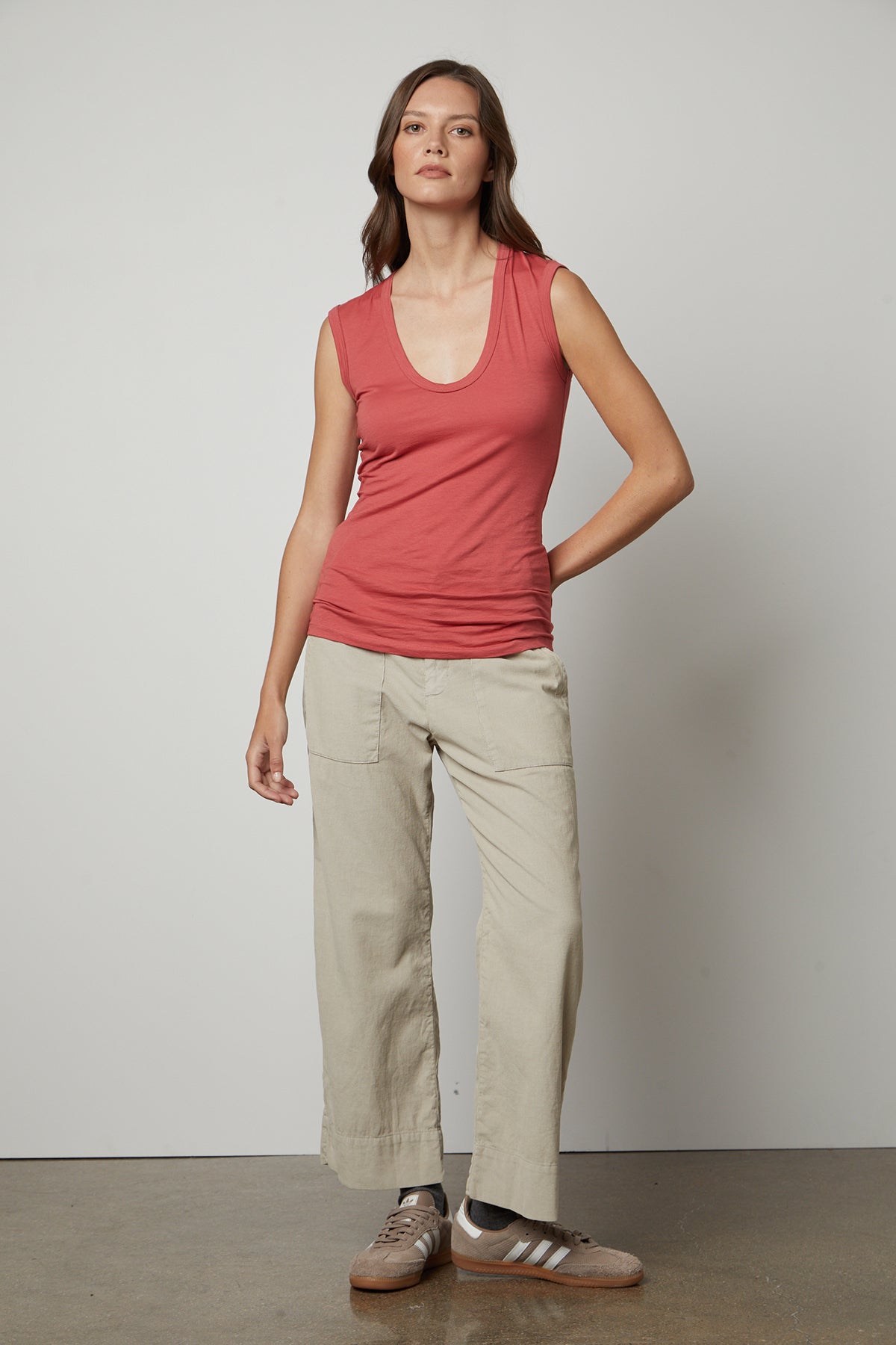   A woman wearing a Velvet by Graham & Spencer ESTINA GAUZY WHISPER FITTED TANK TOP and khaki pants. 
