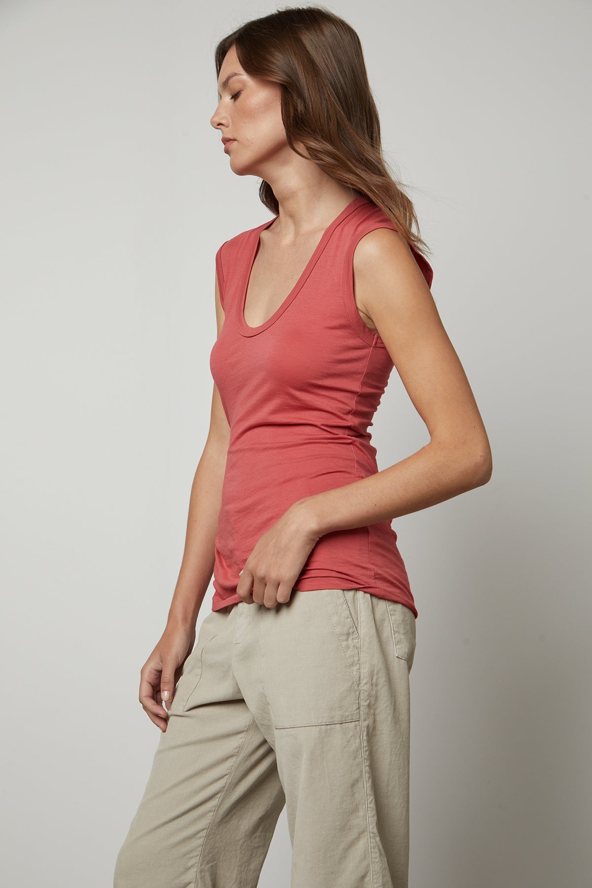 A woman wearing an ESTINA GAUZY WHISPER FITTED TANK TOP by Velvet by Graham & Spencer and khaki pants.-35782798147777