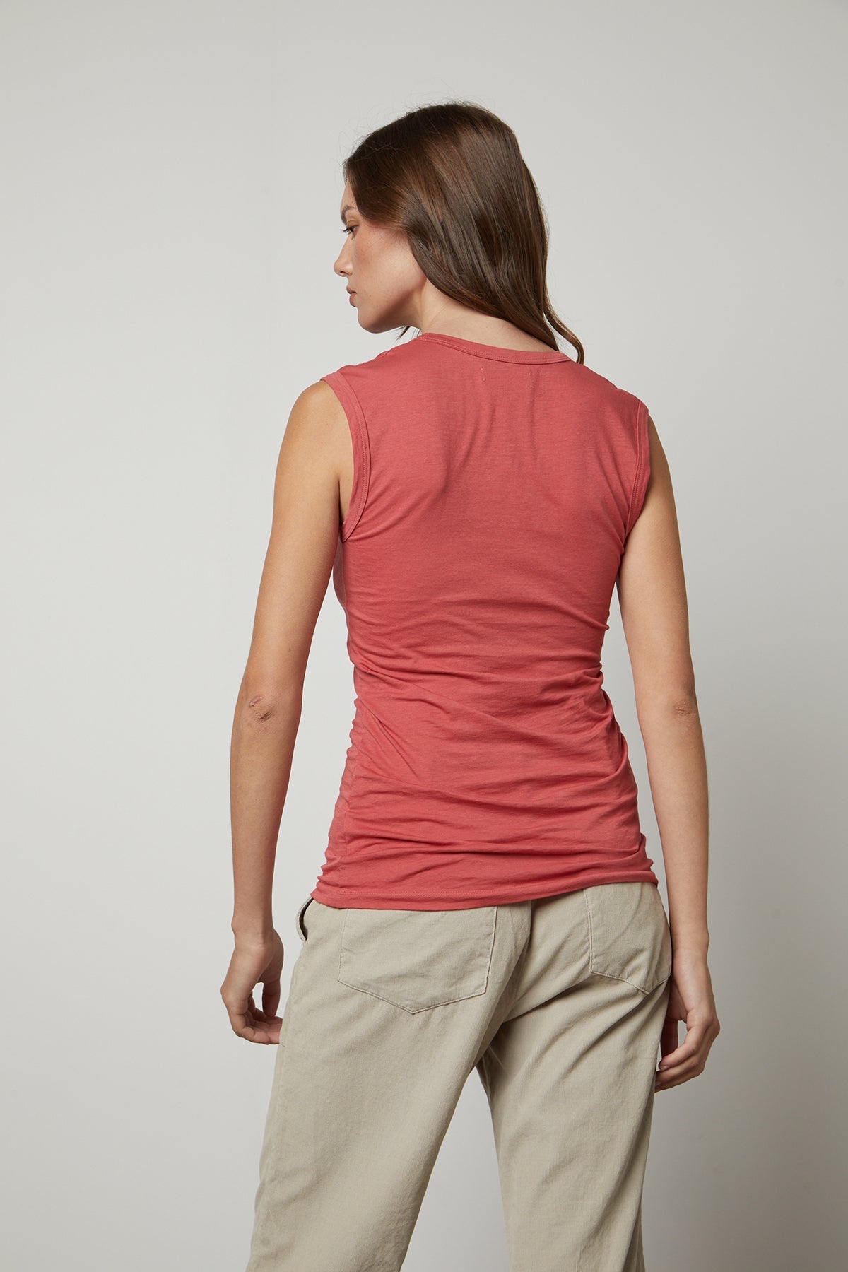   The back view of a woman wearing a Velvet by Graham & Spencer ESTINA GAUZY WHISPER FITTED TANK TOP and khaki pants. 
