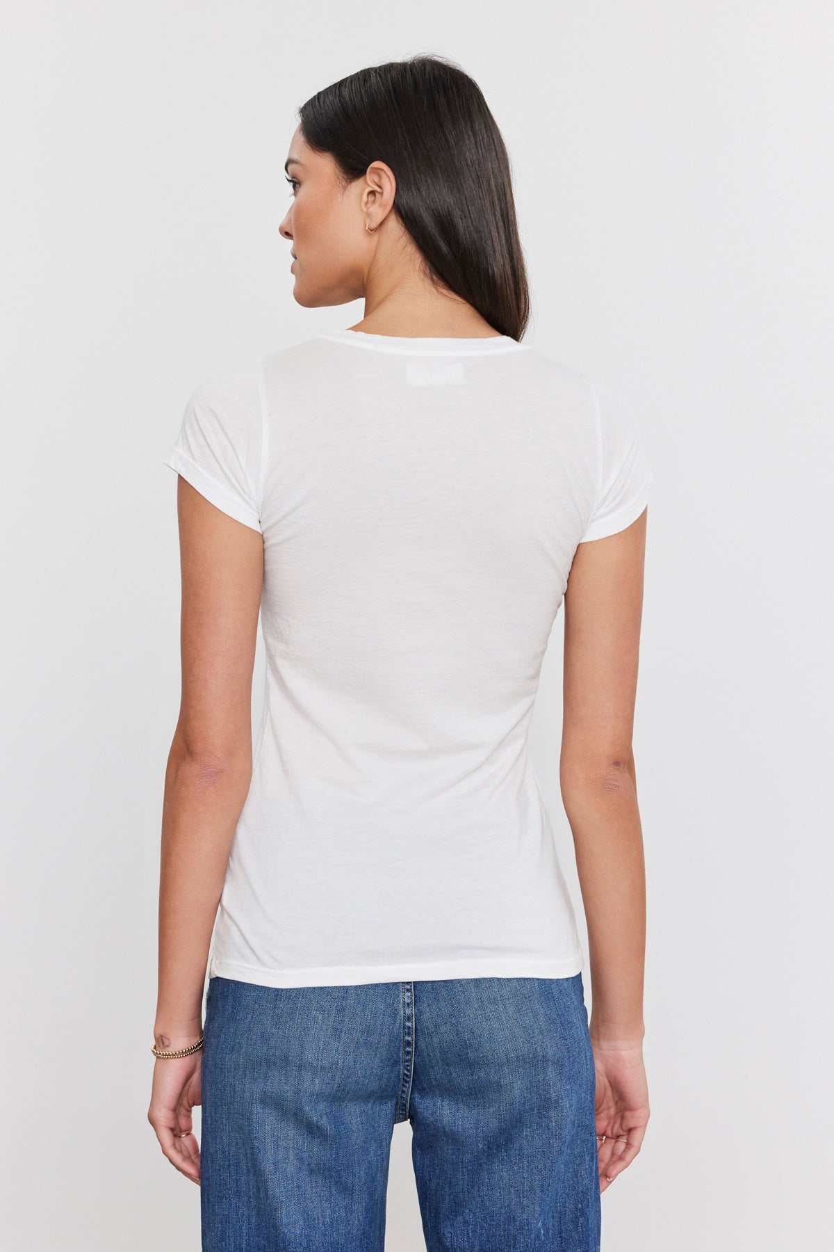 The back view of a woman wearing a Velvet by Graham & Spencer JEMMA GAUZY WHISPER FITTED CREW NECK TEE, jazzed up by the softest gauzy whisper cotton.-35586101346497
