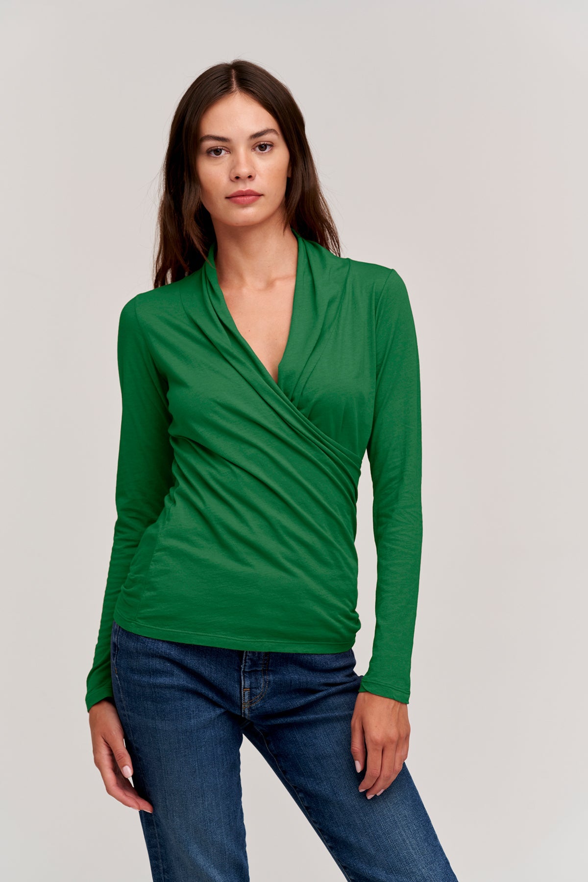   a woman wearing a Velvet by Graham & Spencer MERI WRAP FRONT FITTED TOP and jeans. 