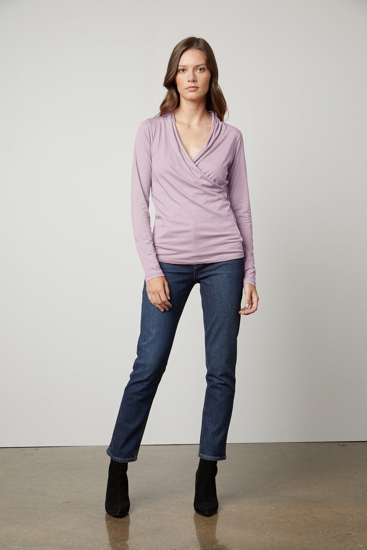   a woman wearing a Velvet by Graham & Spencer MERI WRAP FRONT FITTED TOP and jeans. 